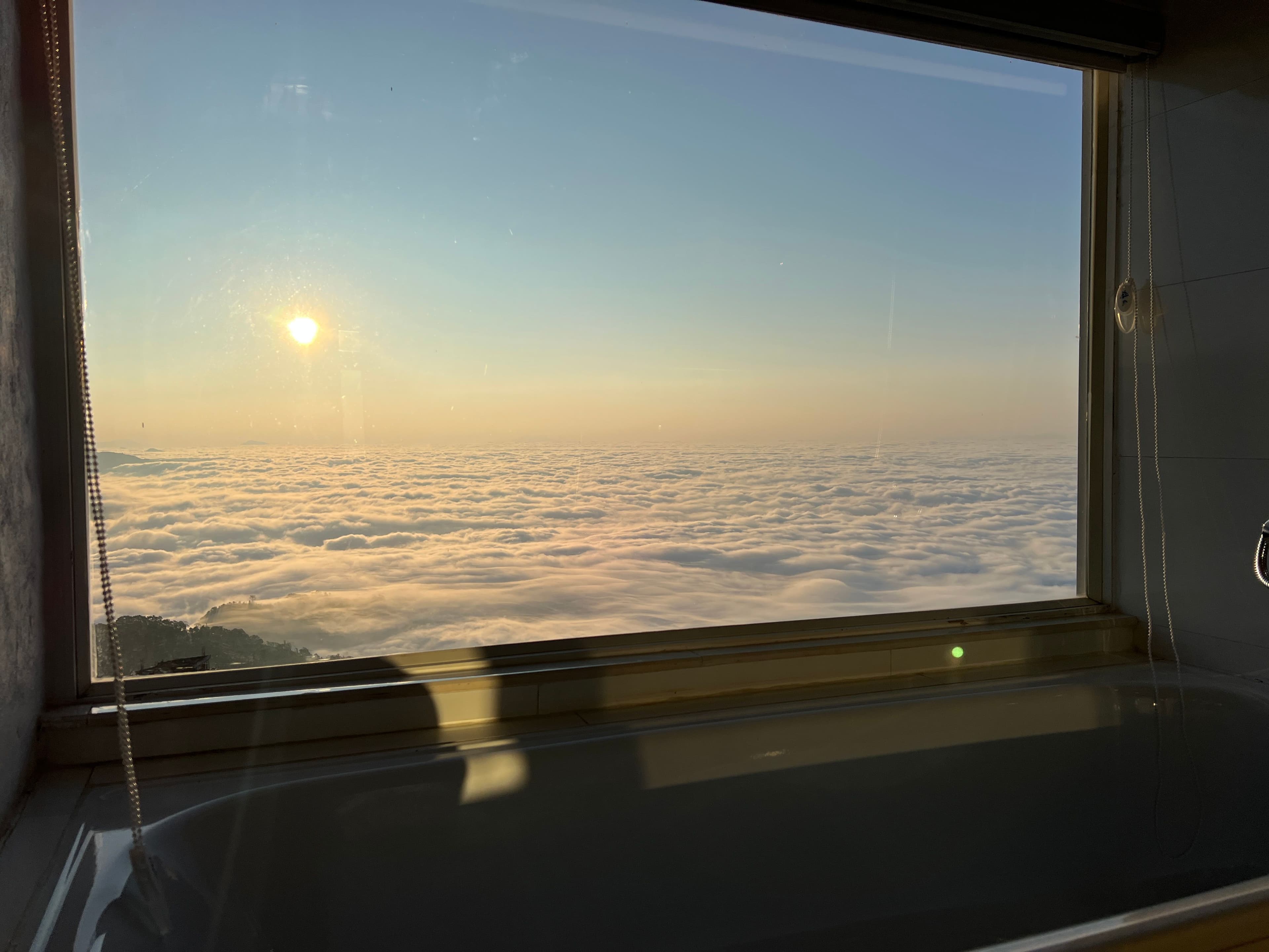 bathtub with the view of sea of clouds during sunrise